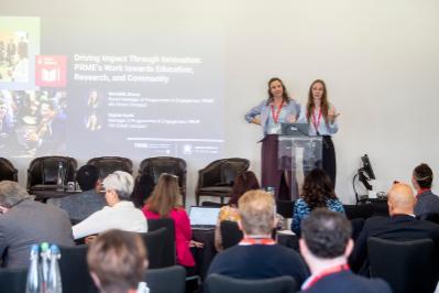 full room with two presenters on stage
